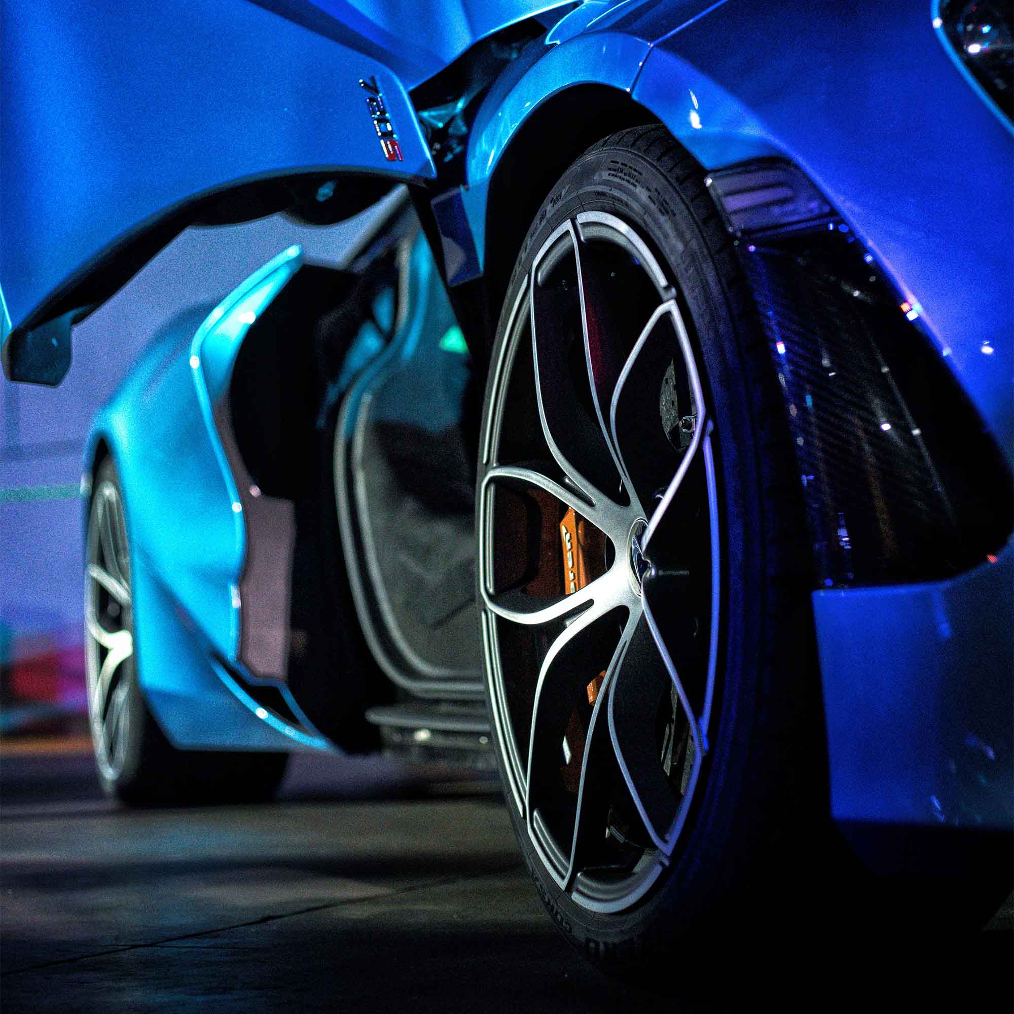 low angle deep perspective photo of a blue super car front to back